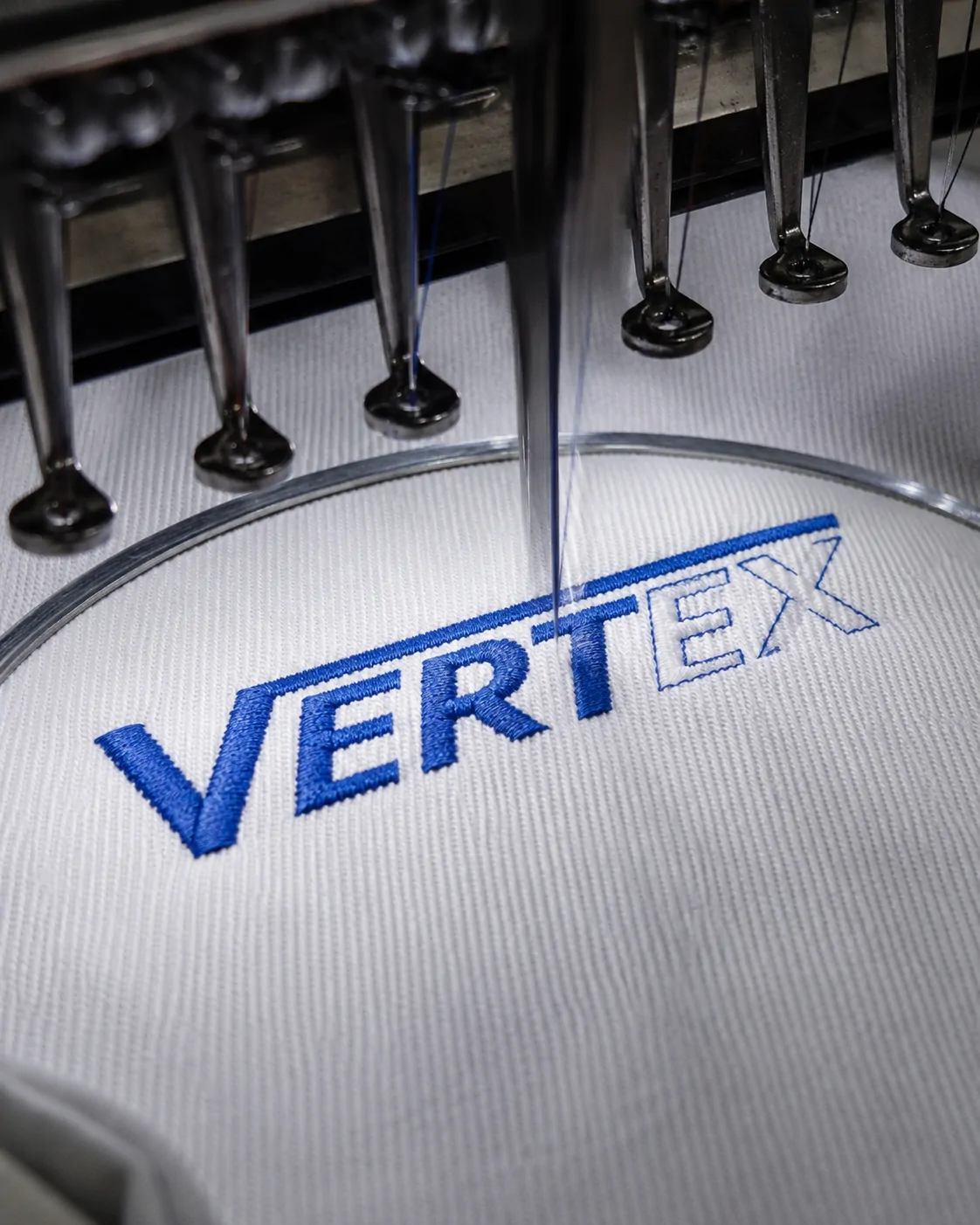 Industrial embroidery machine applying a custom apparel logo