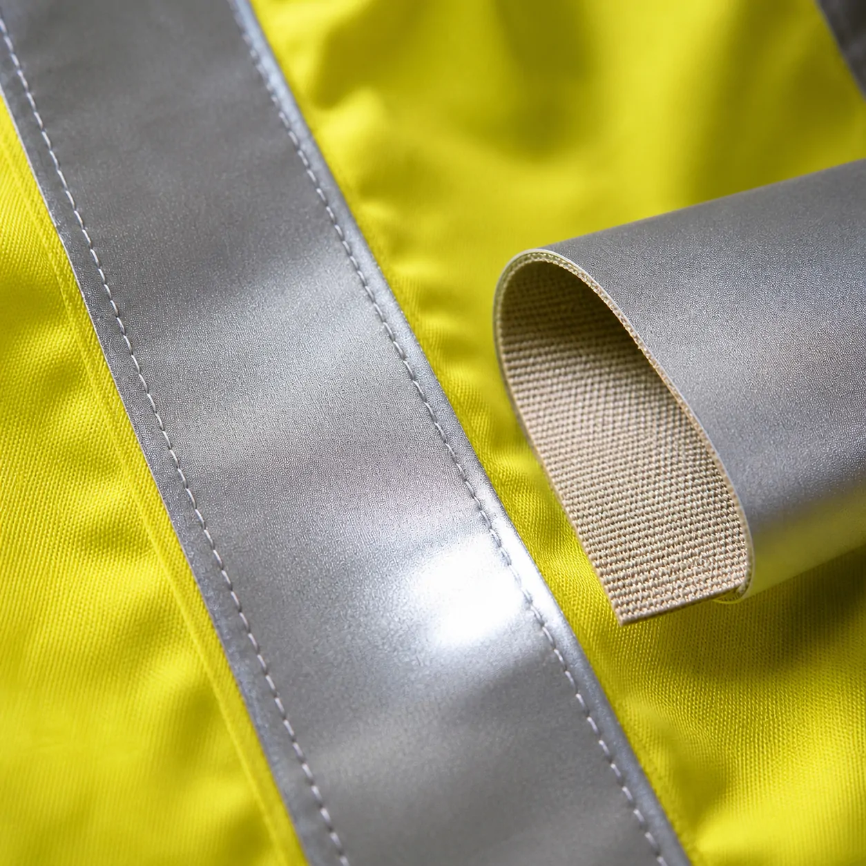 Reflective tape stitched to high-visibility fabric